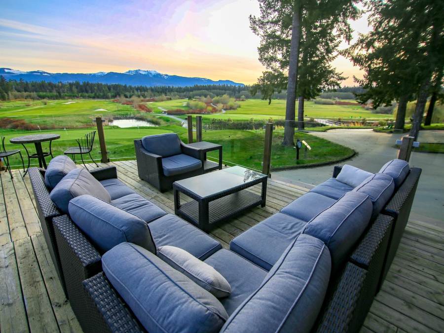 View from large outdoor sectional couch of Pheasant Glen Golf Resort greens and mountain in Qualicum Beach, British Columbia