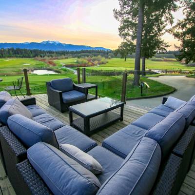 View from large outdoor sectional couch of Pheasant Glen Golf Resort greens and mountain in Qualicum Beach, British Columbia