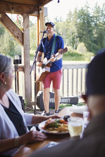 A performer giving live music at an outdoor restaurant in Parksville Qualicum Beach.