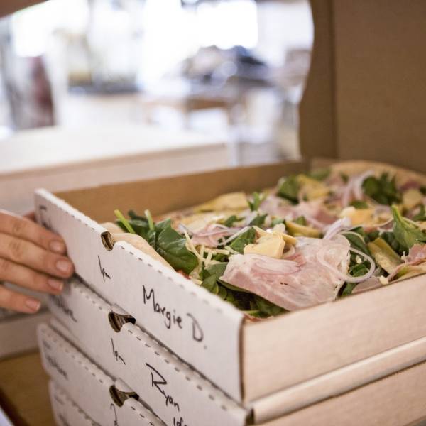 a stack of freshly made pizzas from Wild Culture Bakery