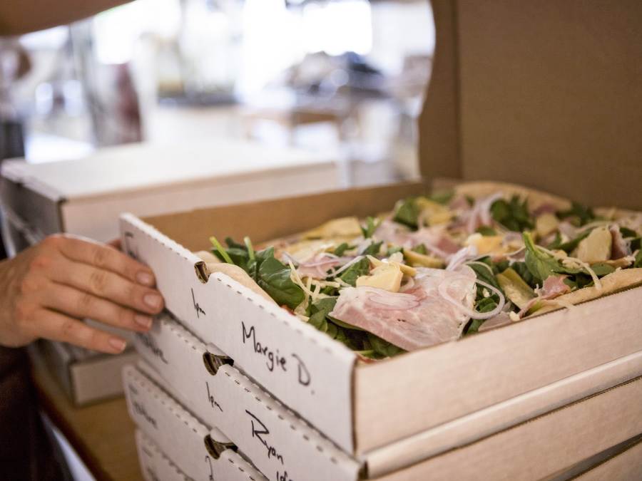 a stack of freshly made pizzas from Wild Culture Bakery