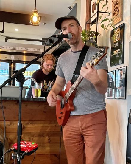 A musician plays guitar and sings at Mount Arrowsmith Brewing