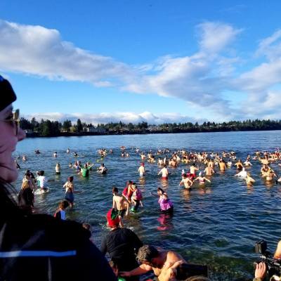 Swimmers wade in the chilly waters off the shore of Parksville Community Beach during a Polar Bear Splash event.