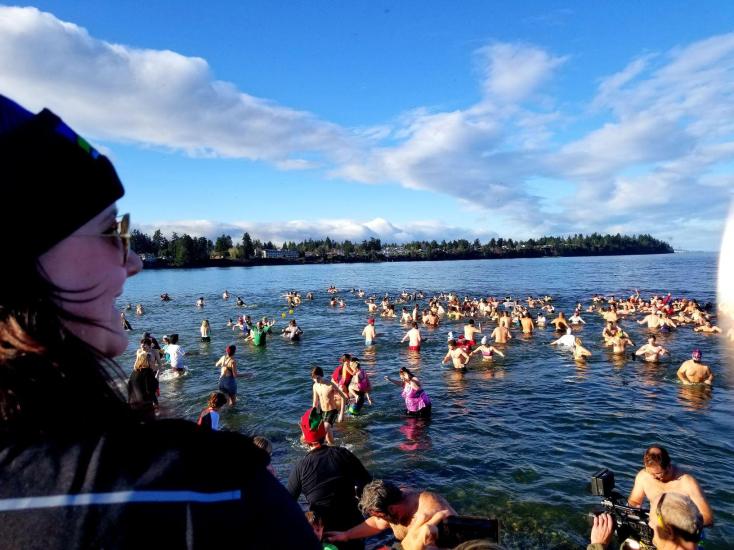 Swimmers wade in the chilly waters off the shore of Parksville Community Beach during a Polar Bear Splash event.