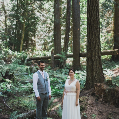 A bride and groom pose for a wedding photo in the forest in Parksville Qualicum Beach