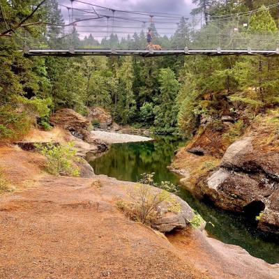 a bridge rises above the water along the Top Bridge Trail at Top Bridge Regional Park, Parksville @allankahhughes