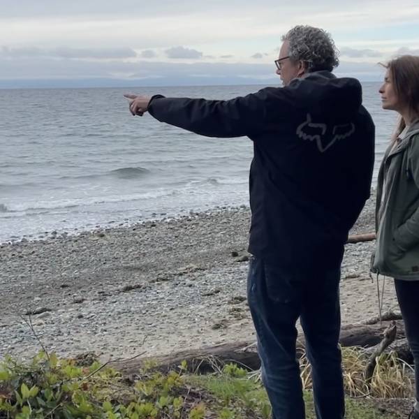 Two people looking at the water of Rathtrevor Beach.