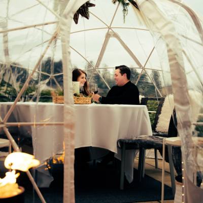 a couple dines inside a heated dome patio at Beach Club Resort