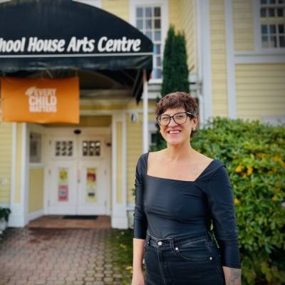 Illana Hester standing in front of The Old School House Arts Centre in Qualicum Beach.