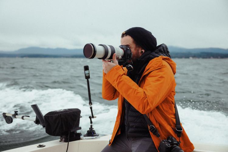JJ Sereday taking photos on a boat during a herring spawn in Parksville, BC