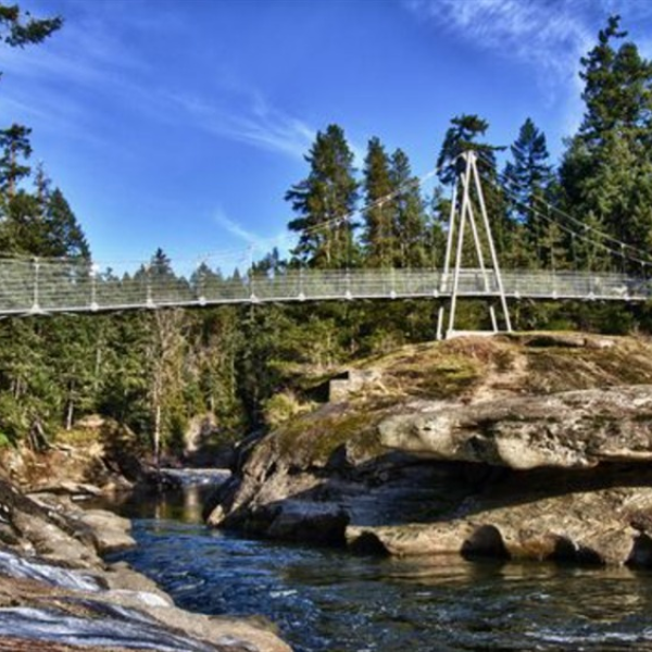 the bridge at Top Bridge Regional Trail rises over the water at Top Bridge Regional Park in Parksville Qualicum Beach