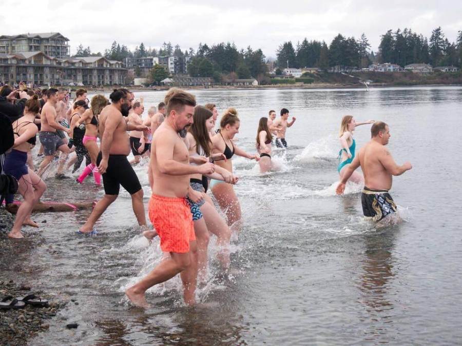 Swimmers wade in the chilly waters off the shore of Parksville Community Beach during a Polar Bear Splash event.