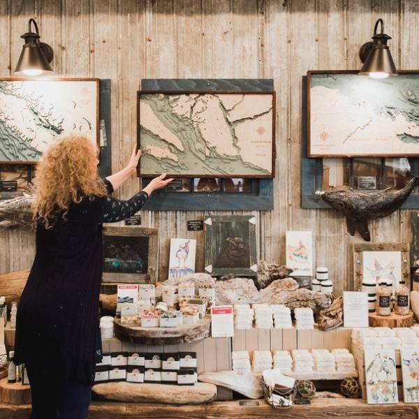 A woman adjusts a an art display at the Salish Sea Market.
