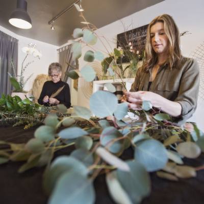 Karen Kuzbik of Petal and Kettle sorts through stems of greenery and florals while preparing wedding decorations