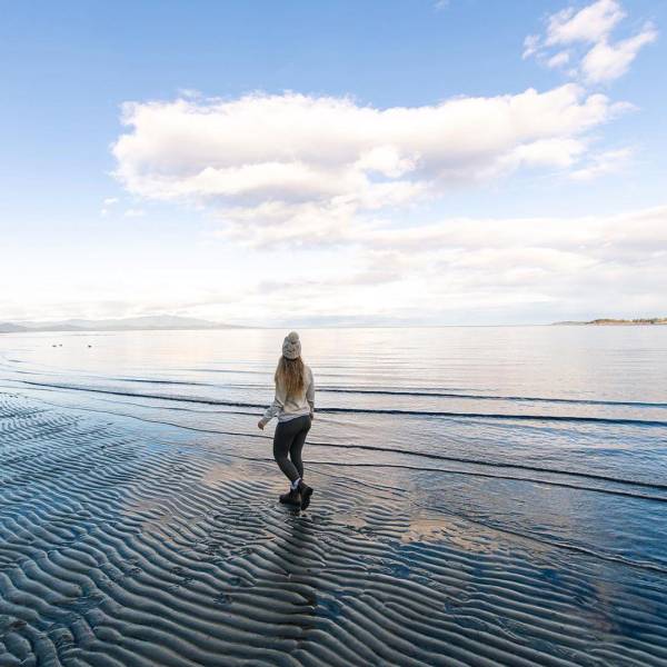 A person standing on the shore of Rathtrevor Beach.