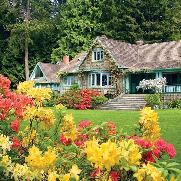 Colorful flowers in front of a charming house at Milner Gardens and Woodland in Parksville Qualicum Beach.