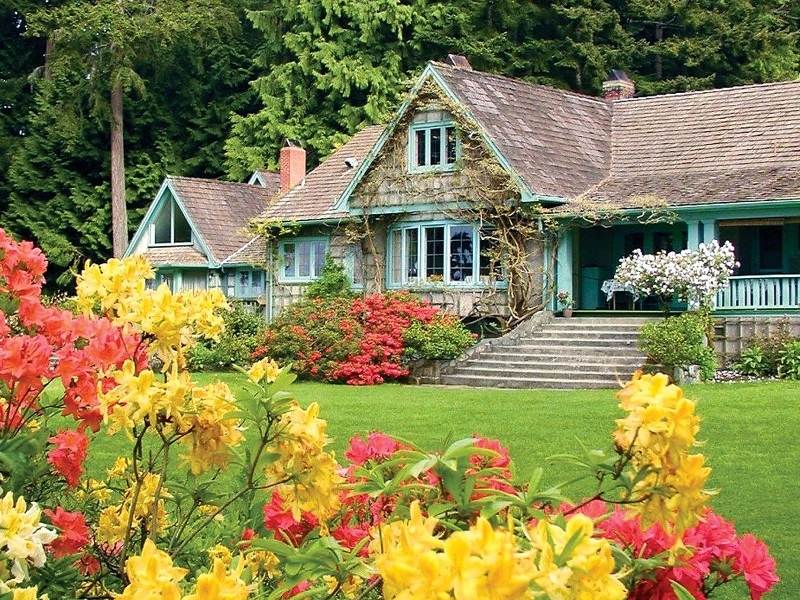 Colorful flowers in front of a charming house at Milner Gardens and Woodland in Parksville Qualicum Beach.