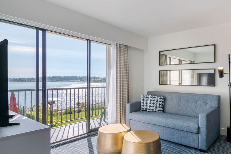 Room at Bayside Oceanfront Resort with a couch, coffee table, and sliding doors to a balcony overlooking the water