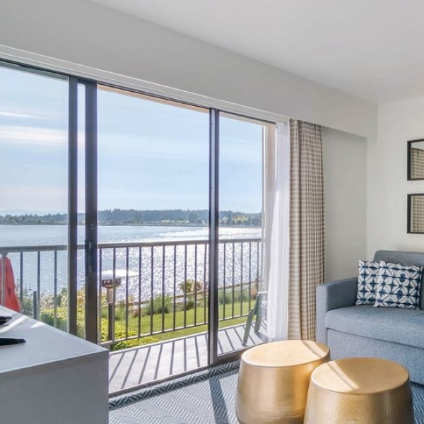 Room at Bayside Oceanfront Resort with a couch, coffee table, and sliding doors to a balcony overlooking the water