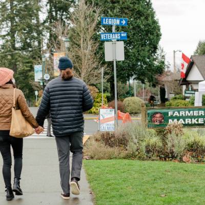 A couple walks hand in hand while taking a stroll through Parksville Qualicum Beach.