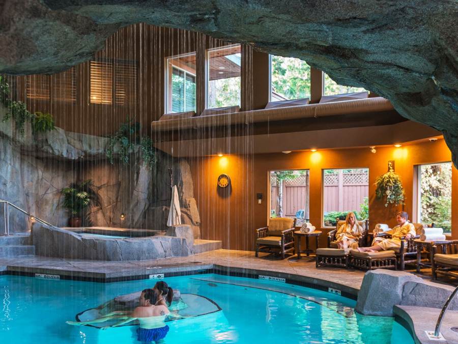 A couple soaks in a cavern-like indoor pool for Tigh Na Mara Dip and DIne in Parksville Qualicum Beach BC