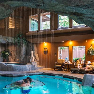 A couple soaks in a cavern-like indoor pool for Tigh Na Mara Dip and DIne in Parksville Qualicum Beach BC