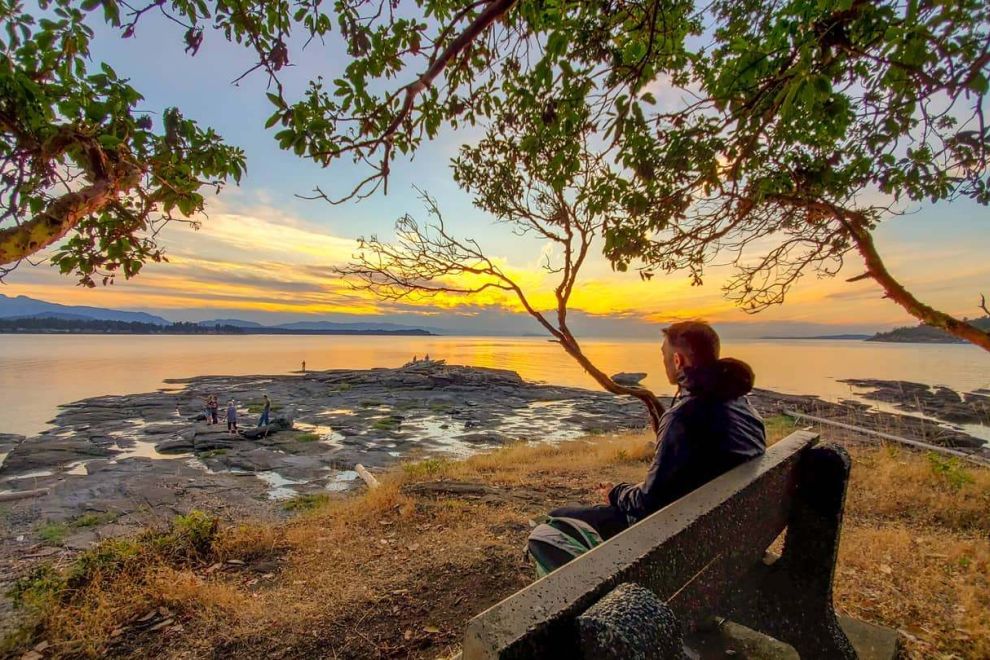 Man sitting on bench in Vancouver Island Parksville Qualicum Beach Beachcomber Regional Park. Image: @telladam