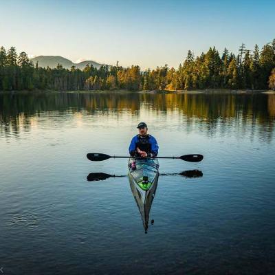 Person in kayak Paddling Calm Waters on lake in Parksville Qualicum Beach BC Canada
