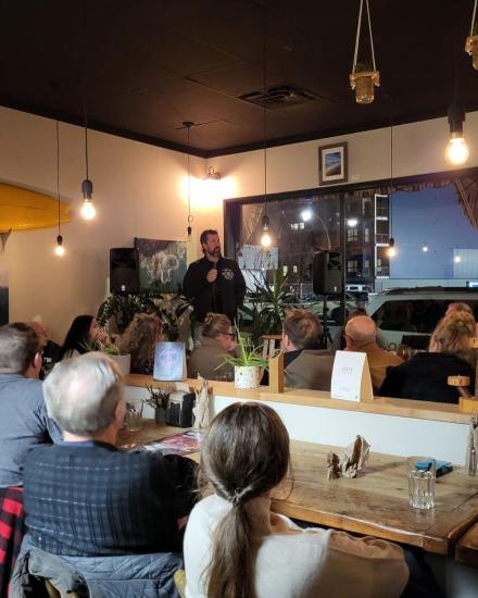 Patrons sit and watch a person perform at Realm Food Co.