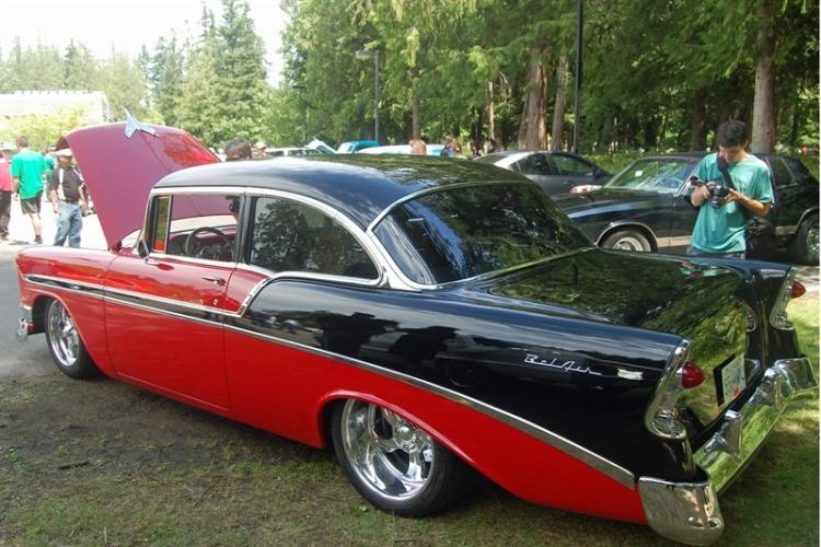 a person photographing a red and black old-school, classic car at the Van Isle Shriners Show & Shine